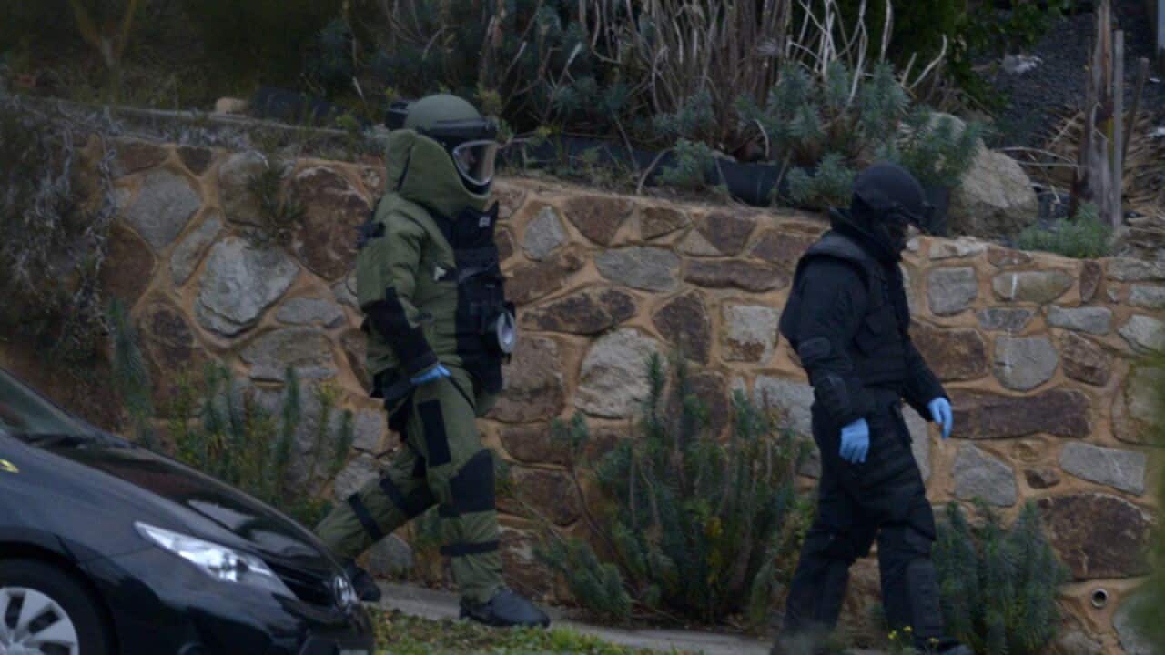 Officers wearing bomb suits