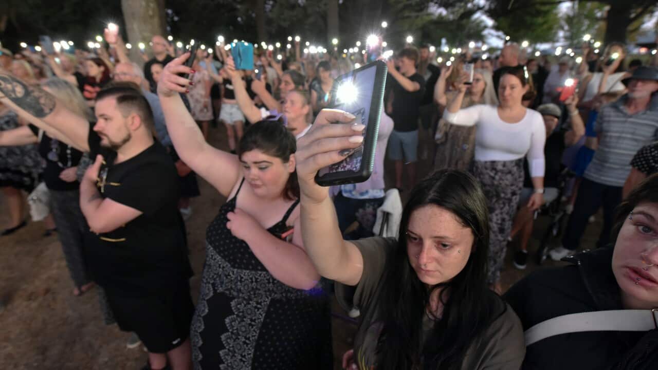 People hold up phones with the torches on