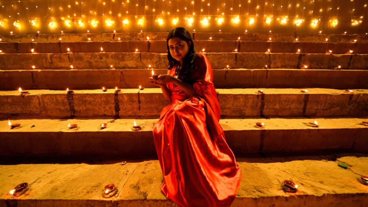 A lady poses for a photo while holding a Diya (Soil Made