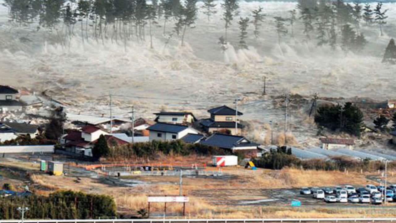 Waves from the tsunami hit residences after a powerful earthquake in Natori, Miyagi prefecture (state), Japan. (AAP)