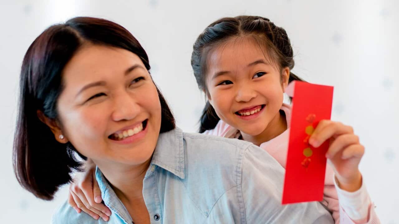 Young holding a red envelope for Chinese new year