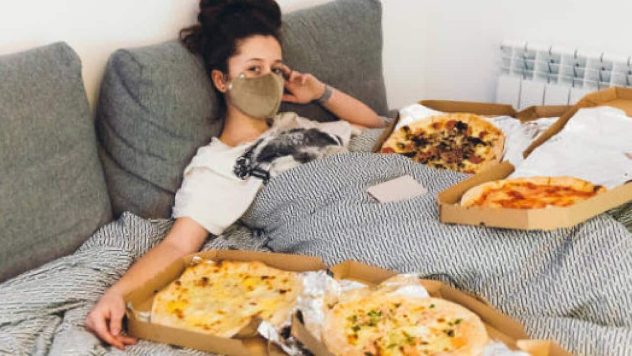 young woman with pizzas in bed