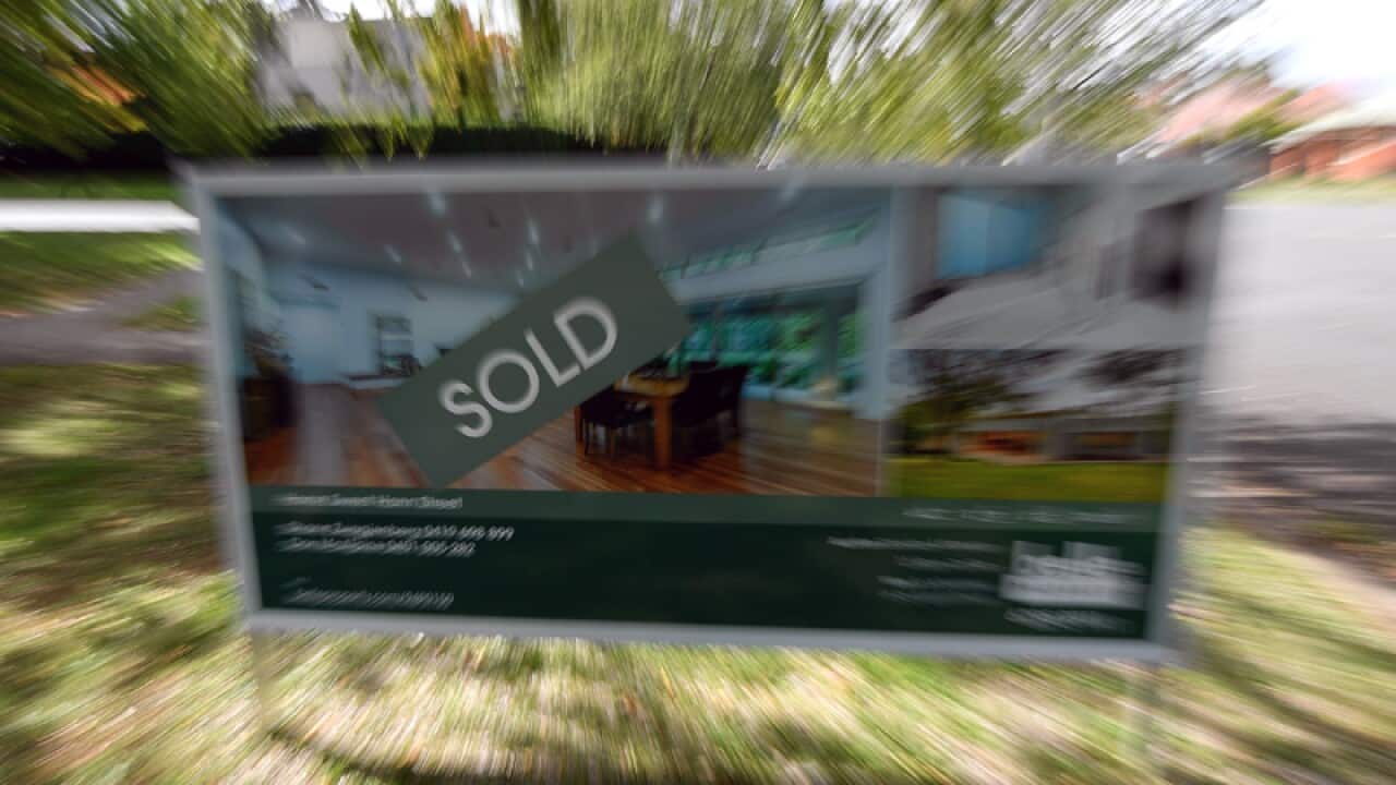A real estate advertising board with a Sold sign