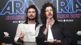 Two young men hold up a white and pointed award.