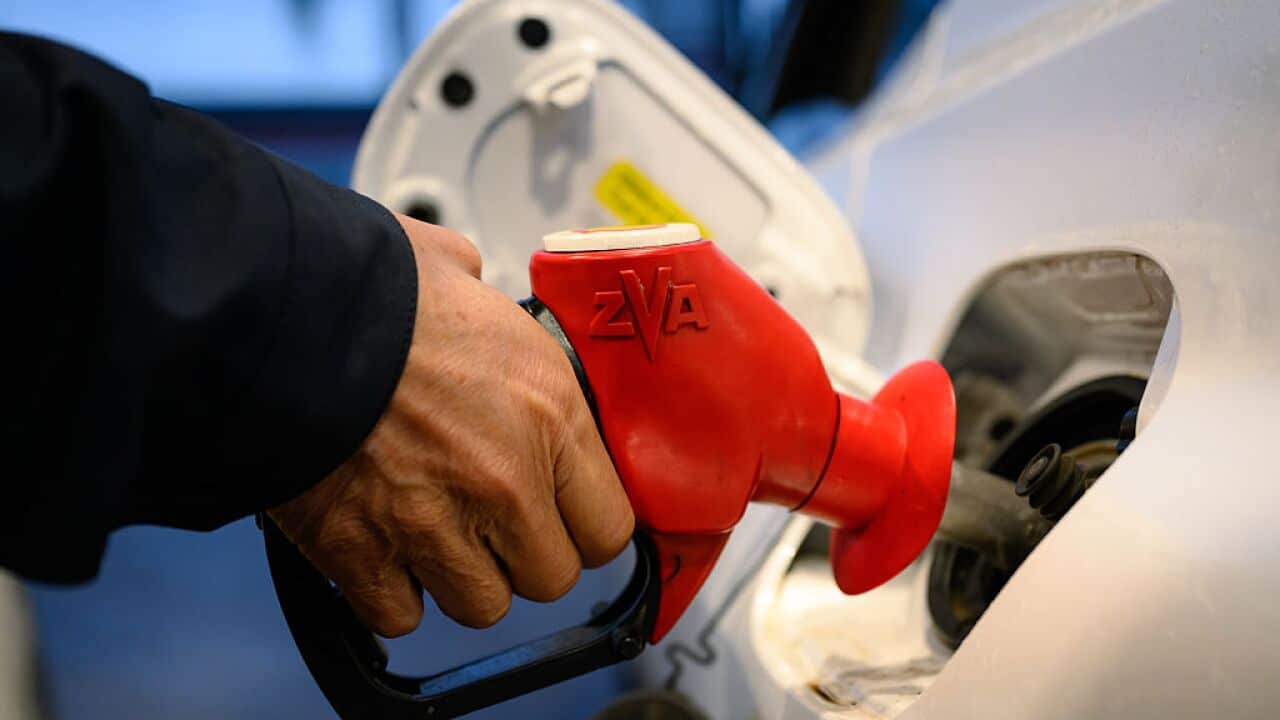 A hand holding a petrol pump