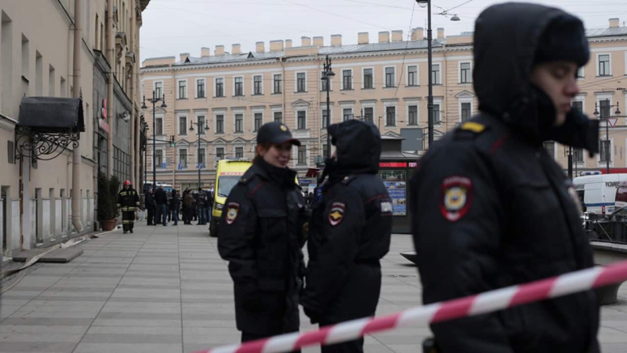 Russian police stand guard after a explosion in St Petersburg's subway