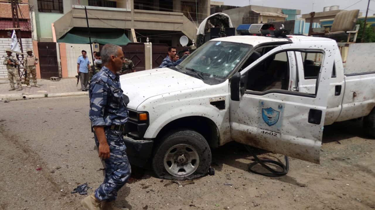 Iraqi soldiers inspect the site of a suicide bombing