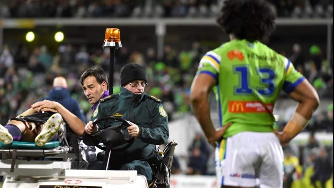 Sia Soliola of the Raiders watches as Billy Slater is stretchered off