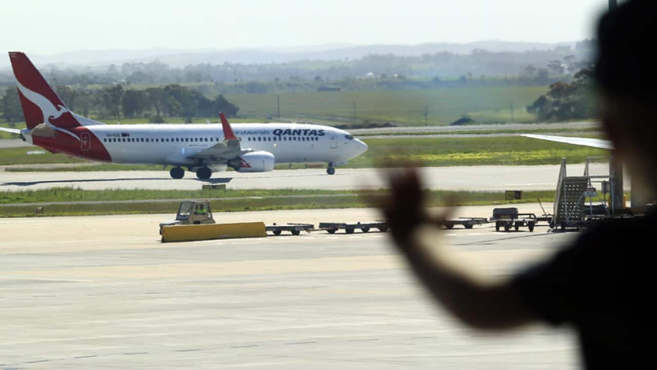 A young boy watching an aircraft at Melbourne Airport