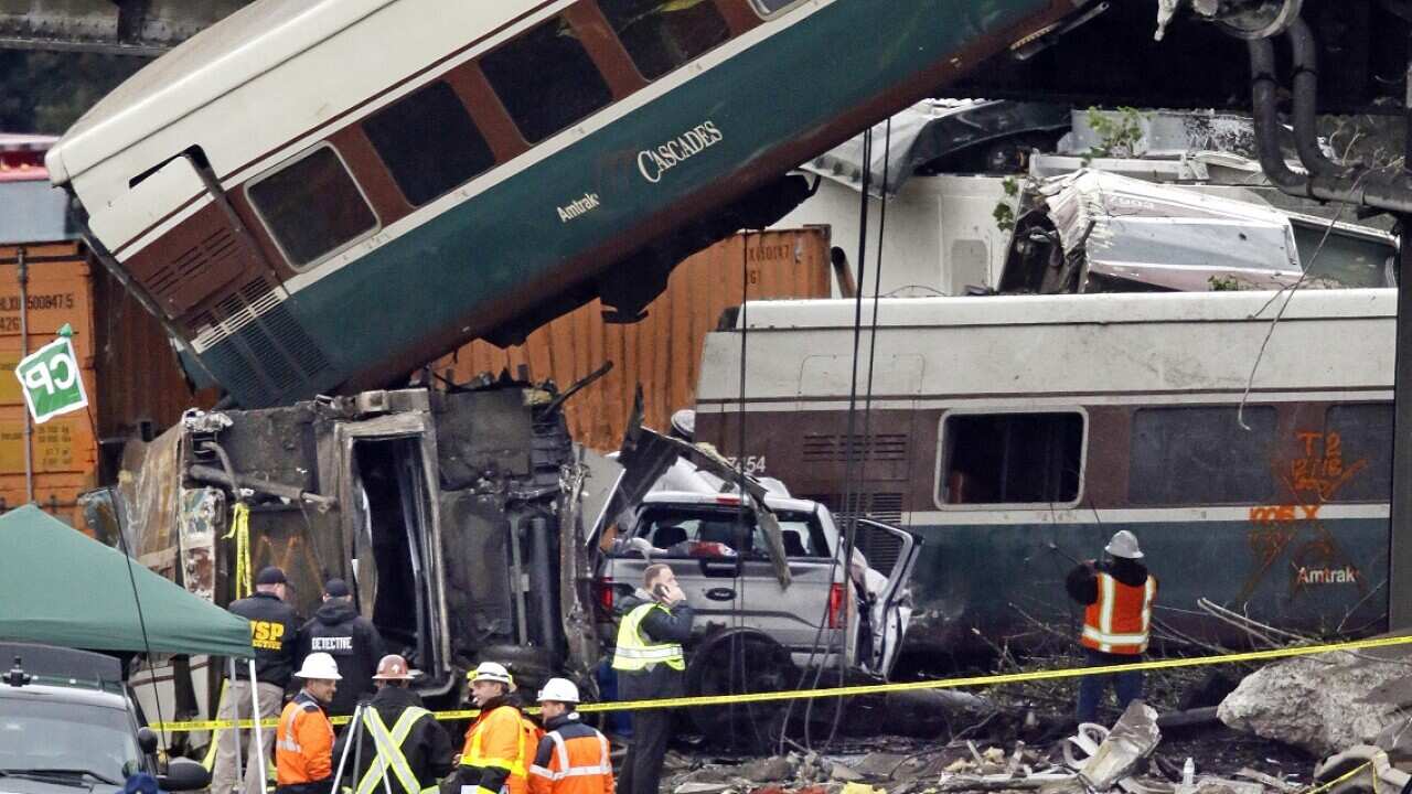 Cars from an Amtrak train that derailed above lay spilled onto Interstate 5 alongside smashed vehicles Monday, 18 December, 2017, in DuPont, Washington.