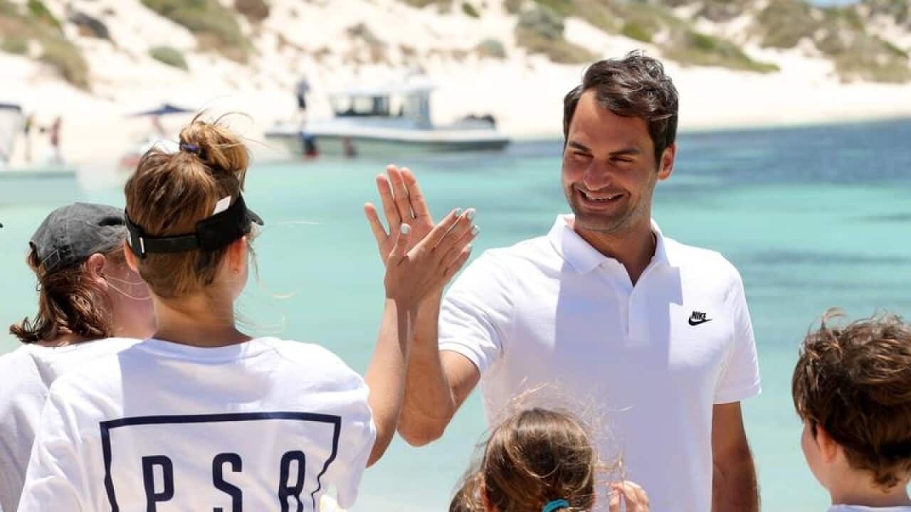 Swiss tennis player Roger Federer is seen greeting children.
