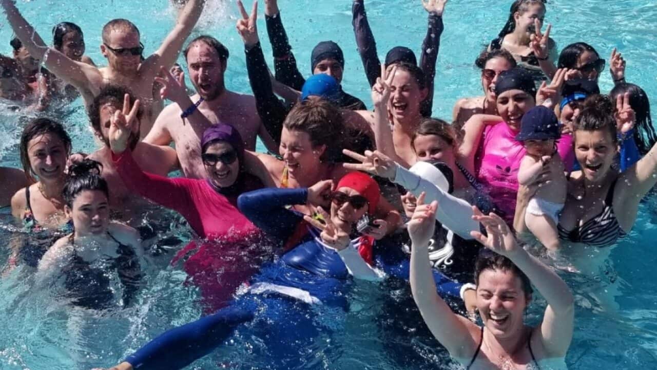 Muslim women are supported by members of the broader community as they wear their burkinis in defiance of this French pool's ban.