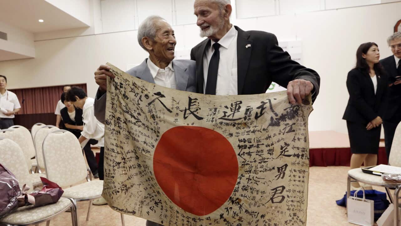 WWII veteran Marvin Strombo returns a Japanese flag to the owner's family