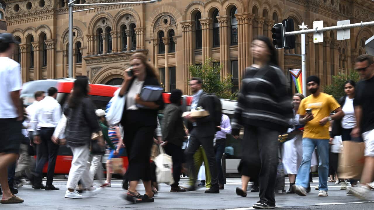 Pedestrians crossing a busy city street in Sydney CBD.