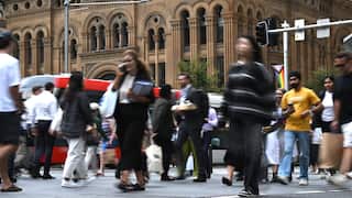 Pedestrians crossing a busy city street in Sydney CBD.