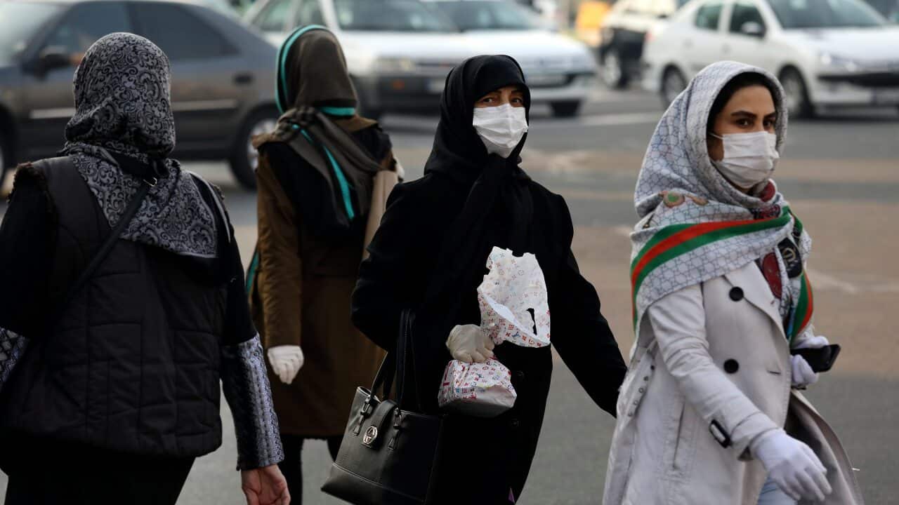Pedestrians wearing face masks cross a square in western Tehran, Iran.