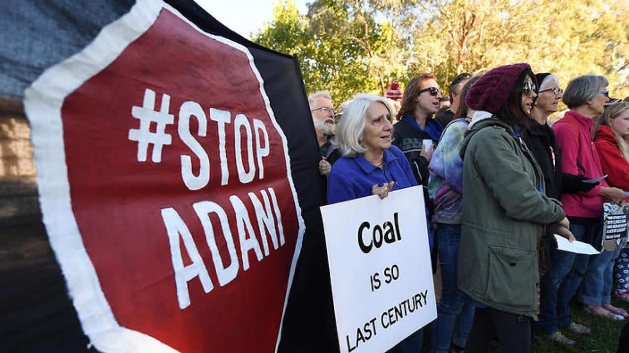 People are seen participating in a protest against the Adani mine outside the Indian High Commission in Canberra, Wednesday, April 12, 2017. (AAP Image/Lukas Coch) NO ARCHIVING