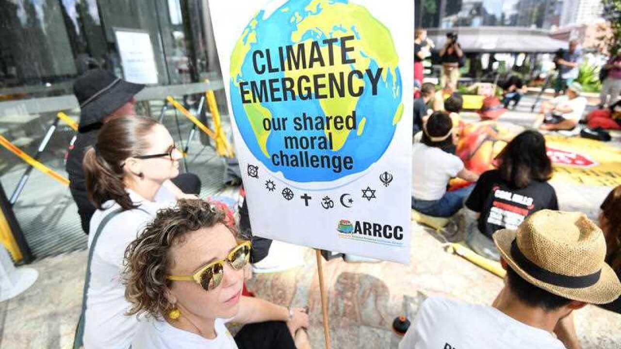 Anti Adani coal mine protestors engage in a sit-in protest outside the Queensland government headquarters in Brisbane, Wednesday, December 12, 2018.
