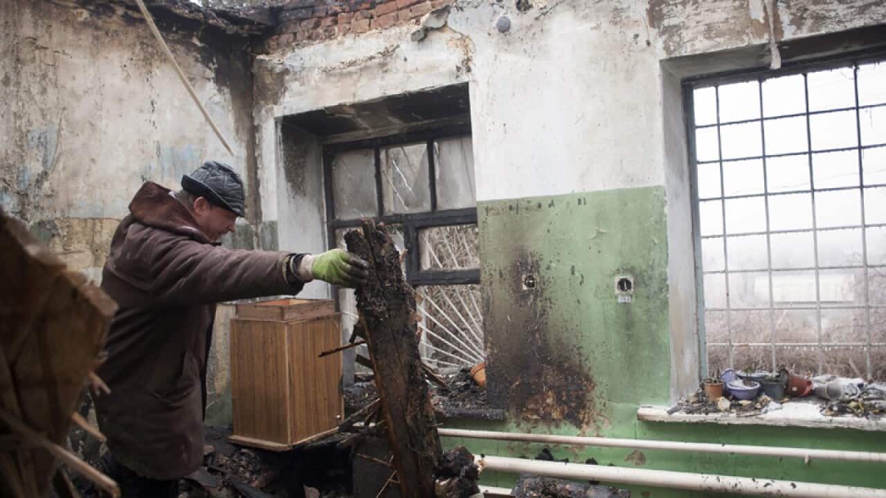 A man inspects a destroyed building after a shelling in Ukraine
