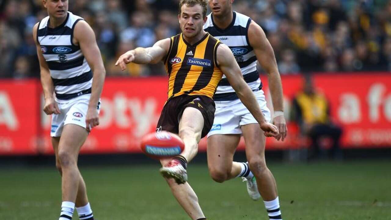 Tom Mitchell of the Hawks (centre)