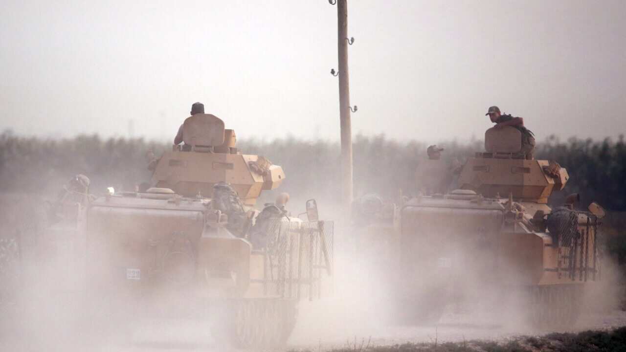 Turkish armored vehicles cross over into northern Syria as part of the attack.