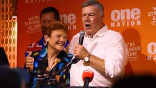 An older white man celebrating with a white woman on a stage