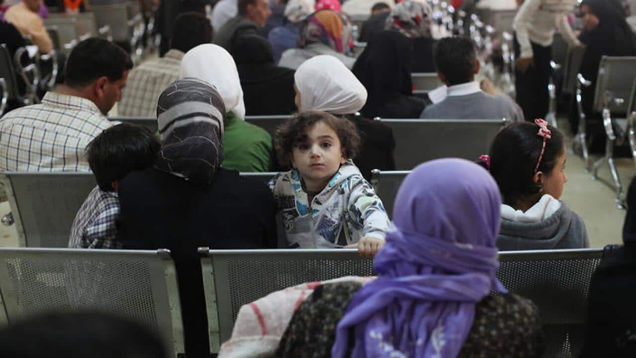 Syrian refugee families wait to be registered with the UNHCR services.