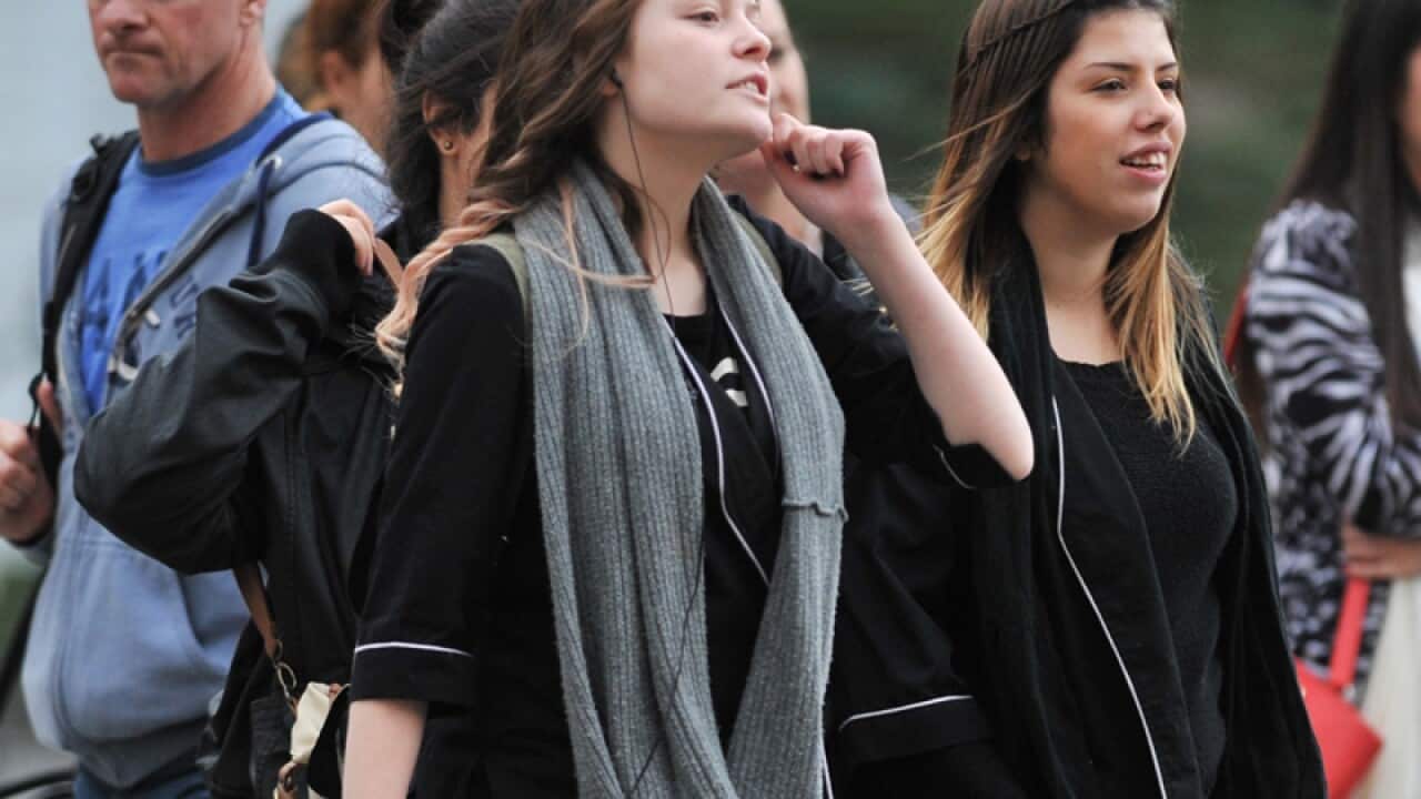 Pedestrians cross a street in Melbourne