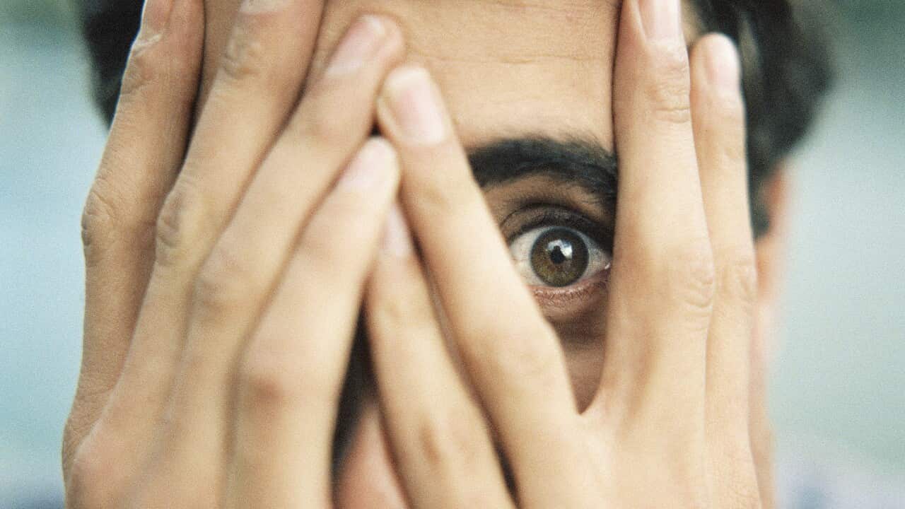 Teenager with hands on face