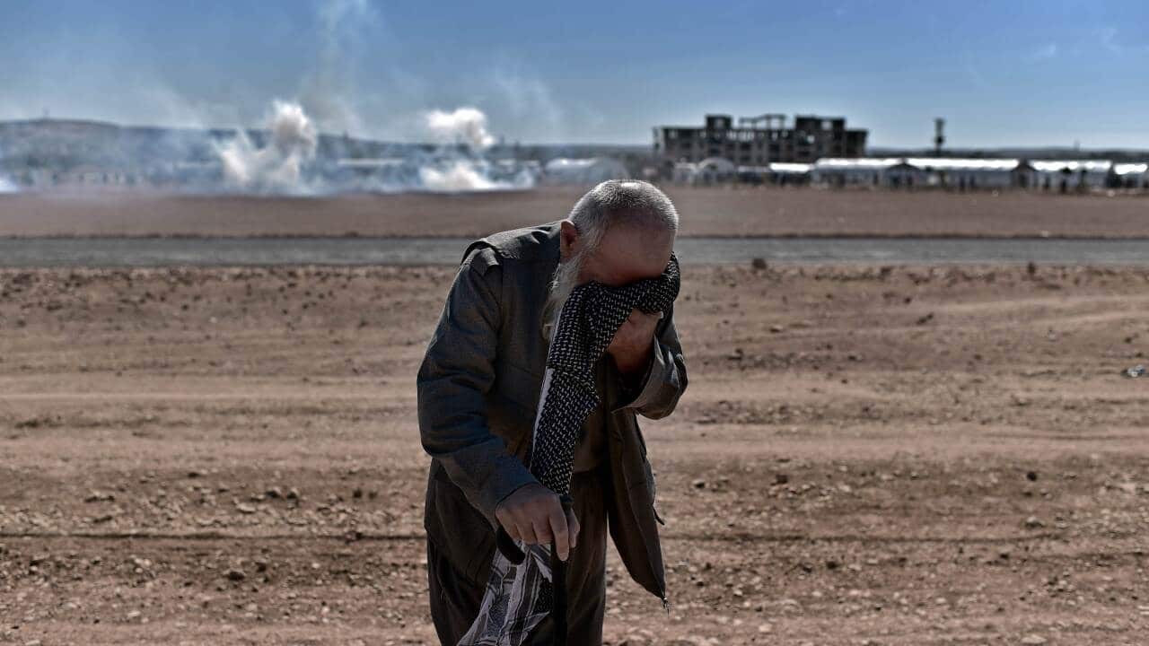 A Kurdish man reacts to tear gas during a clash between Turkish soldiers and Kurdish protesters near the Mursitpinar border crossing on the Turkish-Syrian border. (AFP)