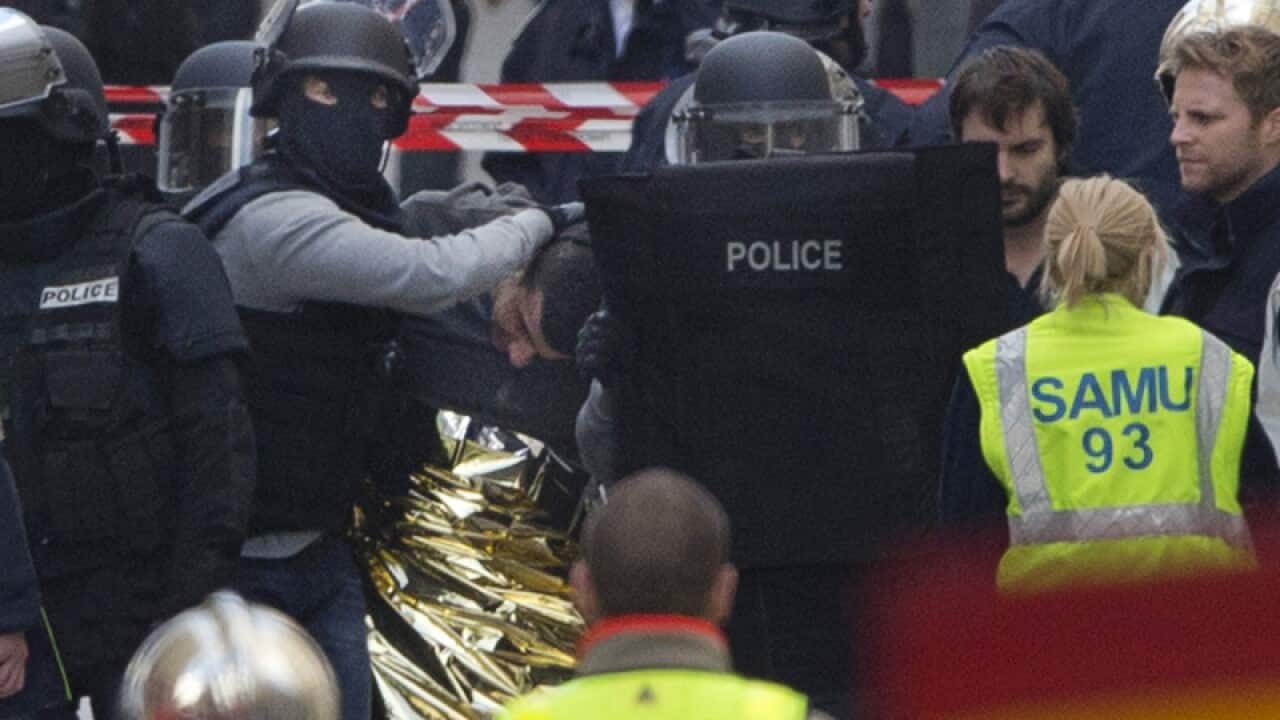 Police officers detain a man in Saint-Denis