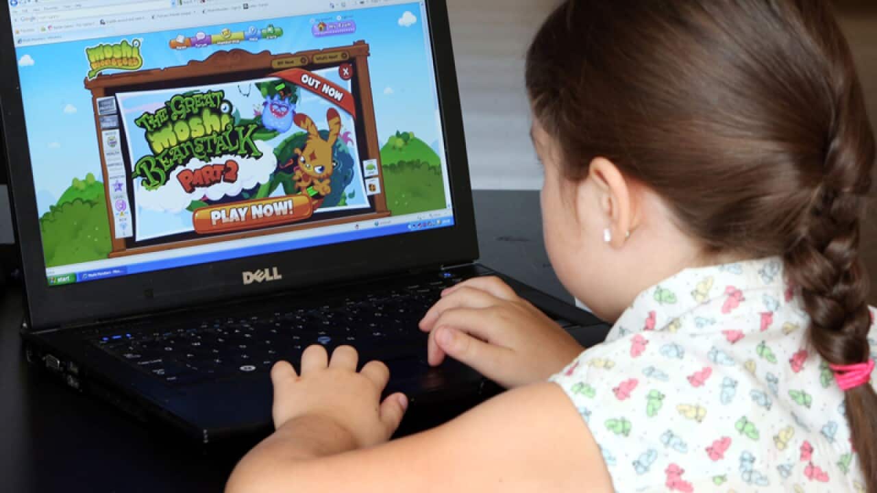 A young girl playing a game on a laptop