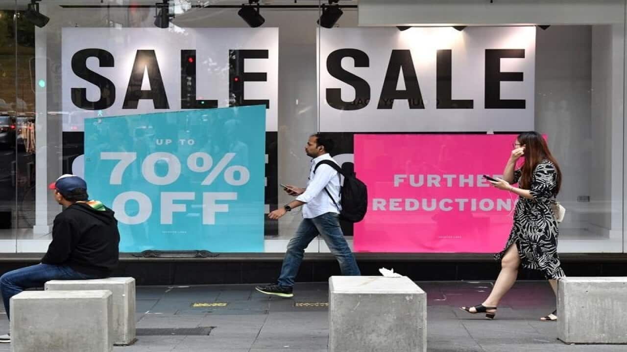 Pedestrians walk past a women's fashion store in Sydney.