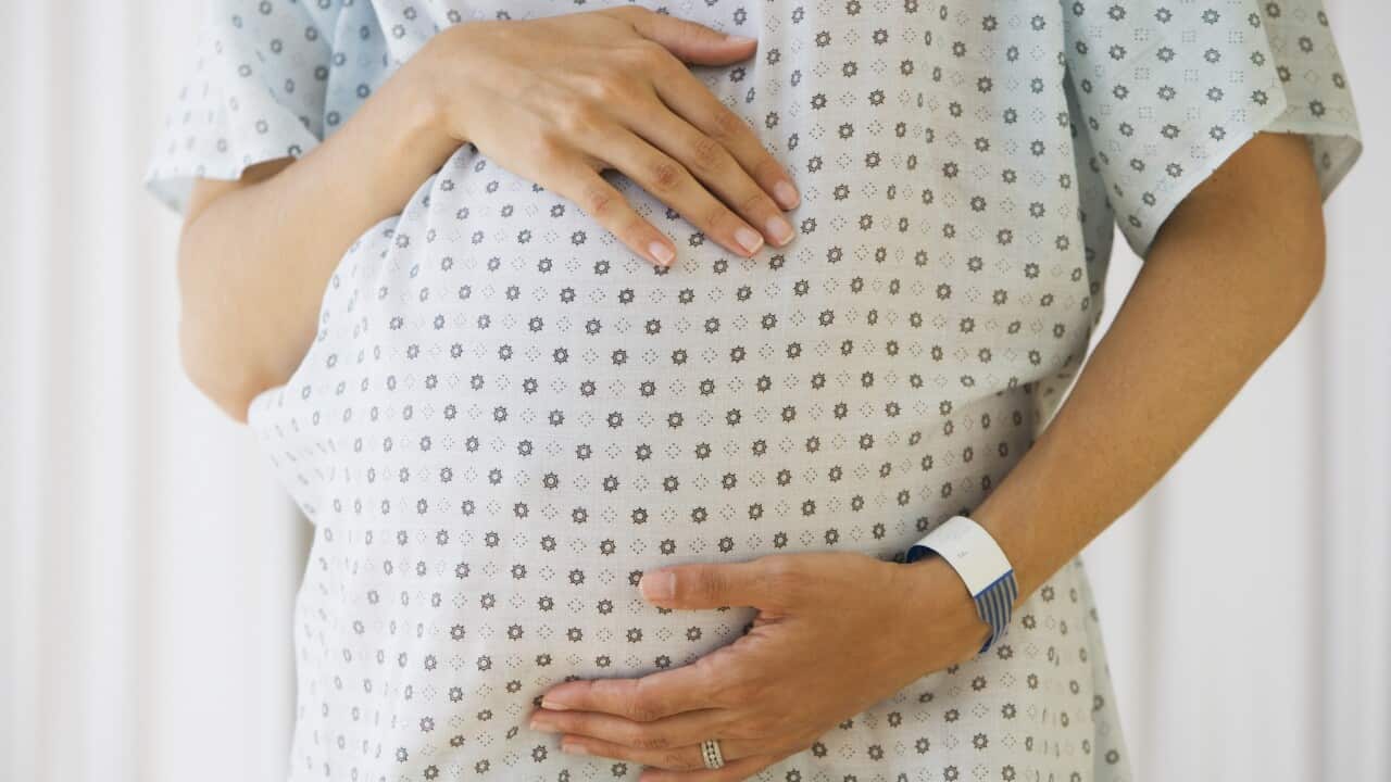 Pregnant woman in hospital gown
