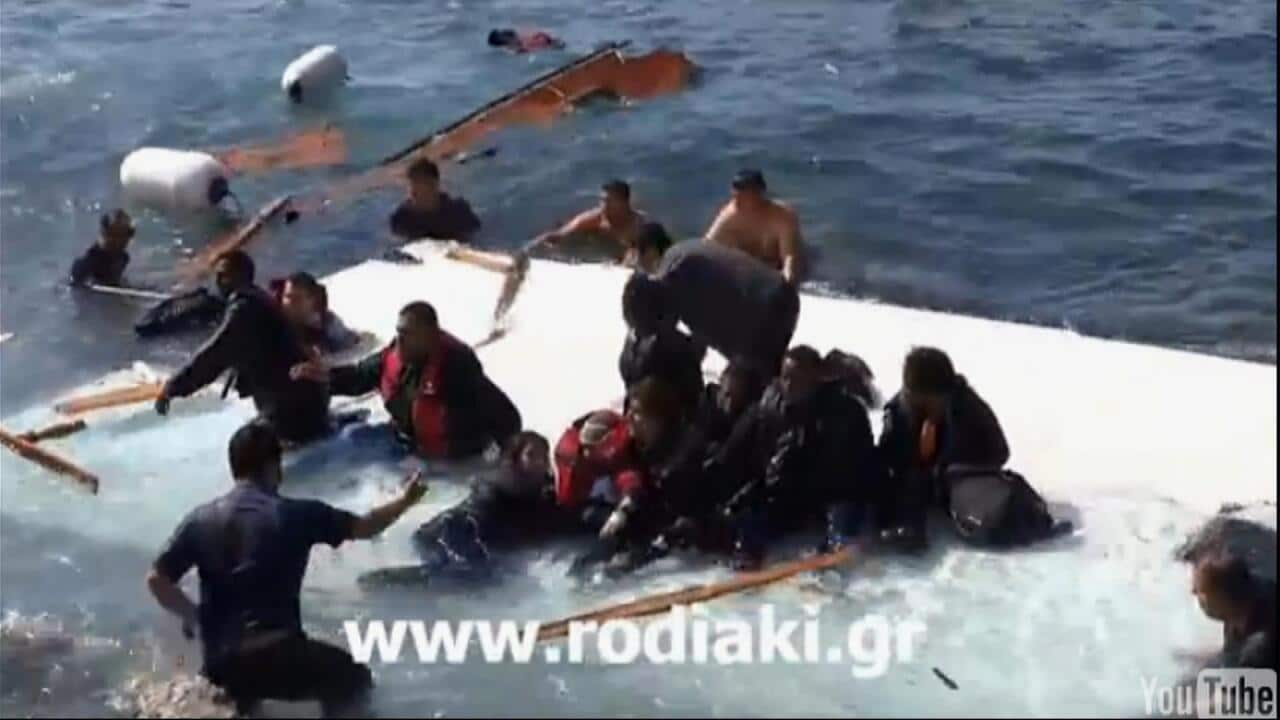 In this image taken from video from www.rodiaki.gr a rescuer, left back to camera, helps migrants from the wreckage in the eastern Aegean island of Rhodes, Greece (www.rodiaki.gr via AP)