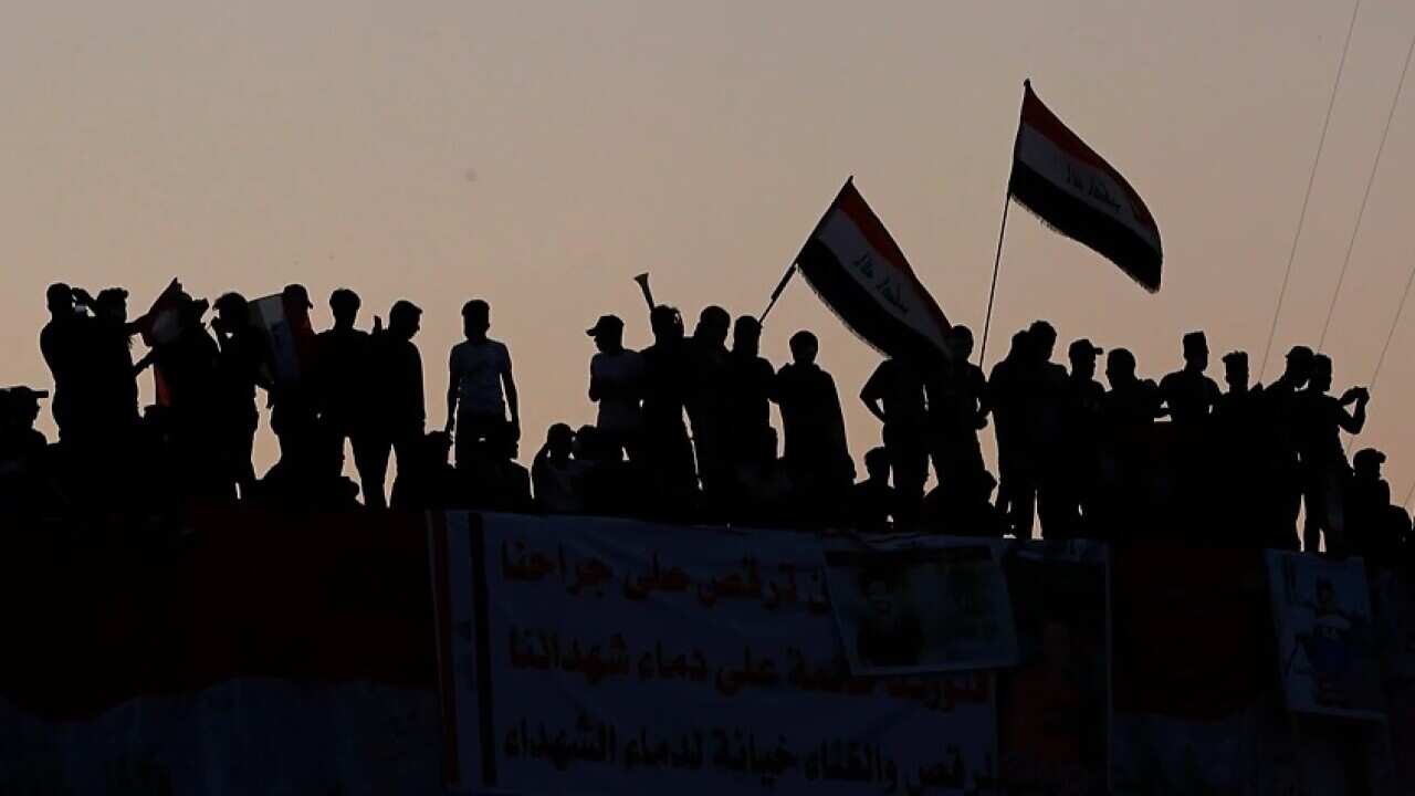 Anti-government protesters stand on a building near Tahrir Square