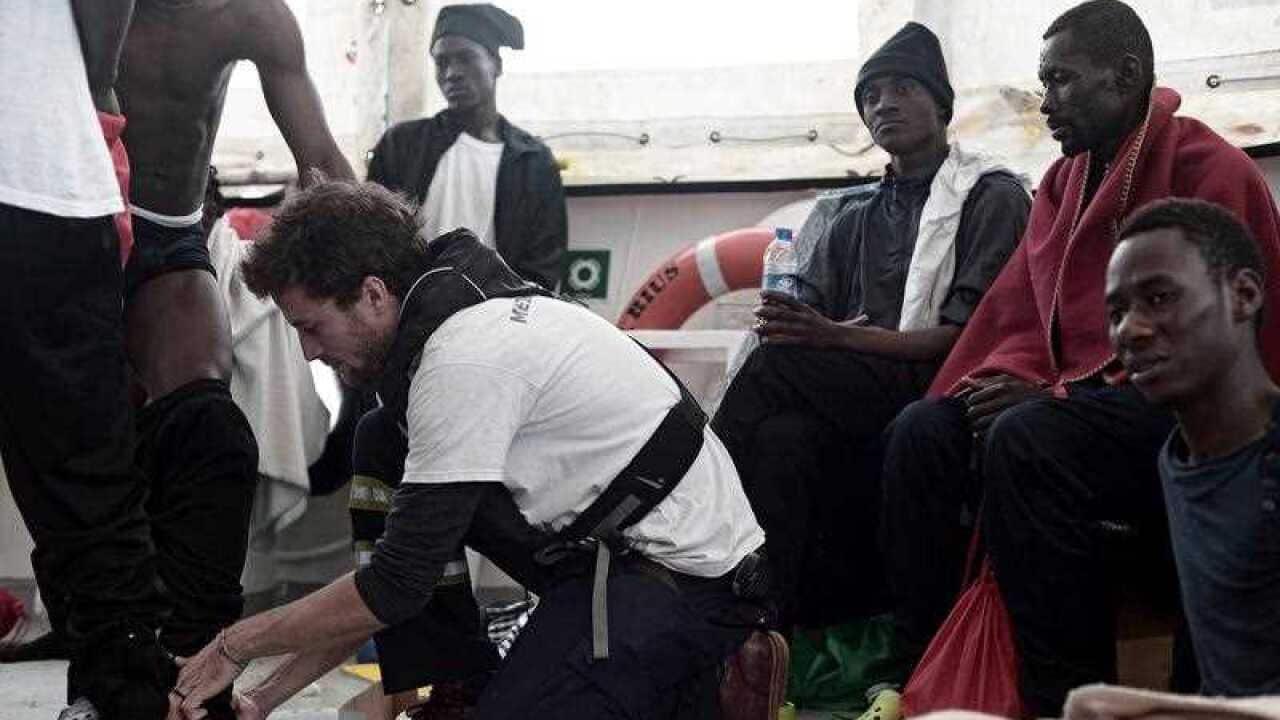 A handout photo made available by NGO 'SOS Mediterranee' shows volunteers and rescued migrants aboard the 'Aquarius' ship at sea in the Mediterranean.