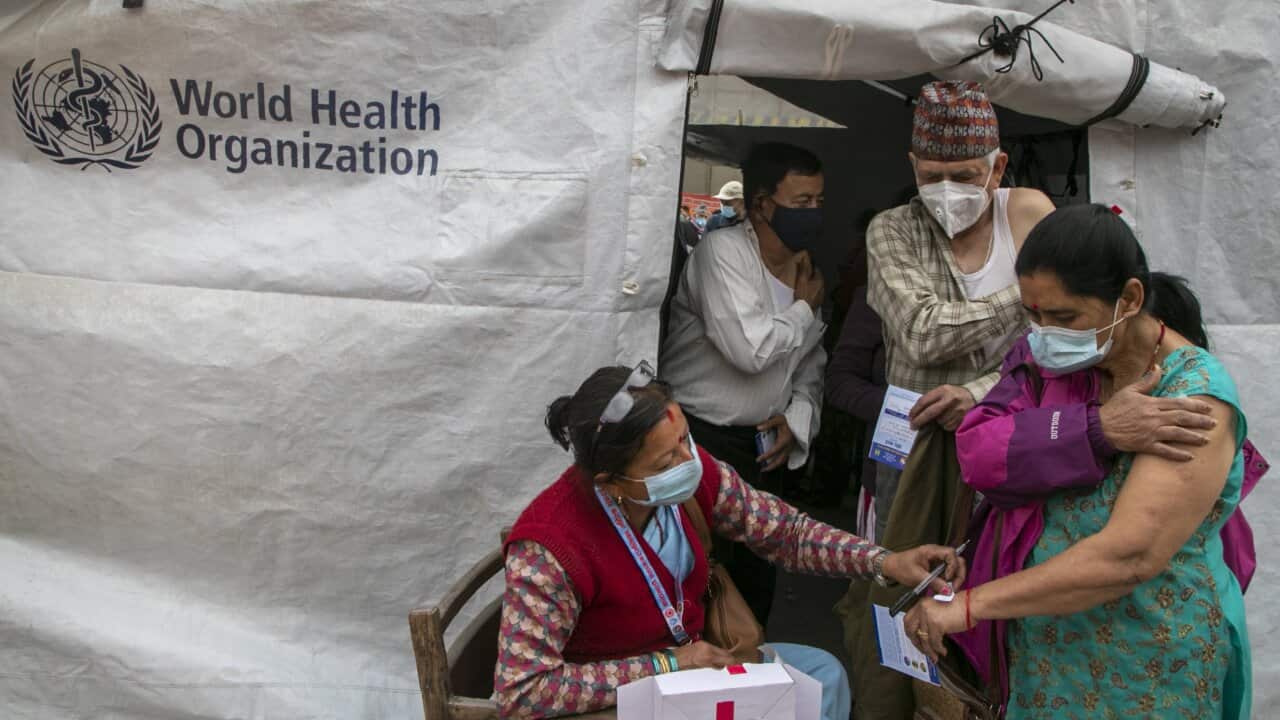A Nepalese health worker sticks a paper that mentions resting time on the hand of elderly people after they received Covishield COVID-19 vaccine in Kathmandu, Nepal, Sunday, March 7, 2021