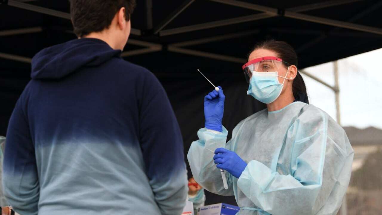 A healthcare worker conducts a COVID-19 test at a pop-up testing facility in Broadmeadows.