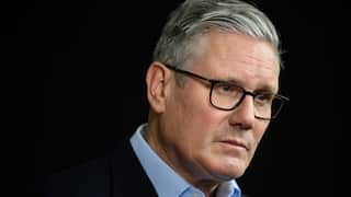 A middle-aged white man wearing glasses and with a slight frown