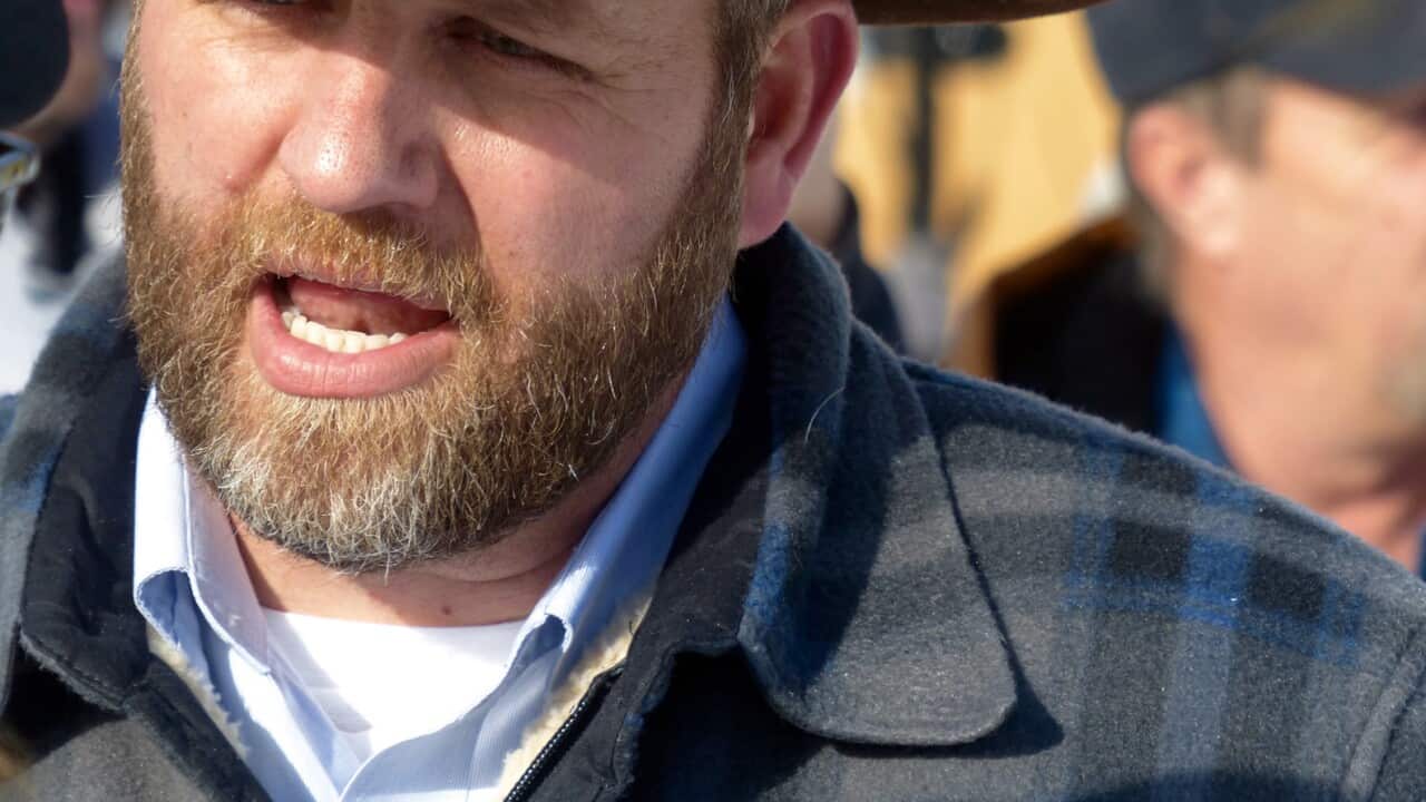 Ammon Bundy chats with a protester Saturday, Jan. 2, 2016, during a march on behalf of a Harney County ranching family in Burns, Ore.