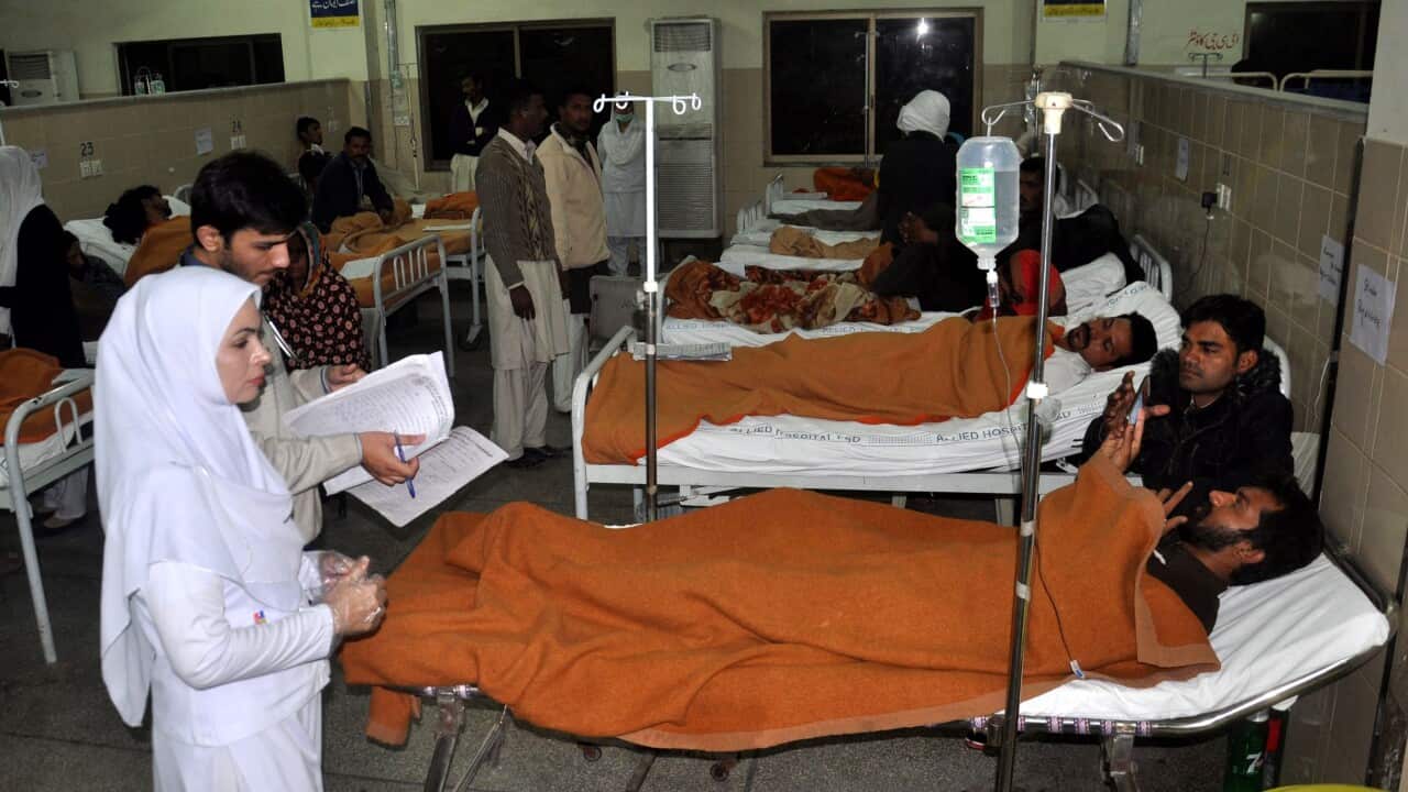 People, who fell unconsious after consuming spurious alcohol, receive medical treatment at a hospital, in Faisalabad, Pakistan
