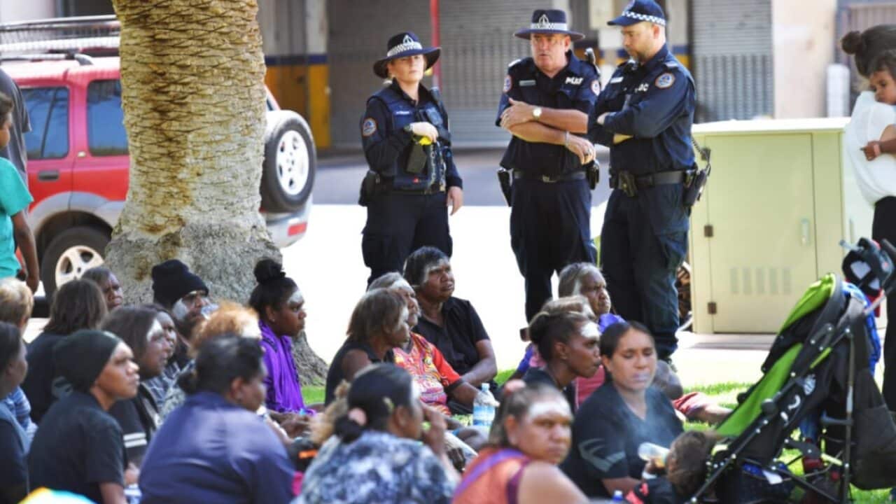 Police watch over relatives of Kumanjayi Walker gathered outside of Alice Springs Local Court on Thursday, December 12, 2019.