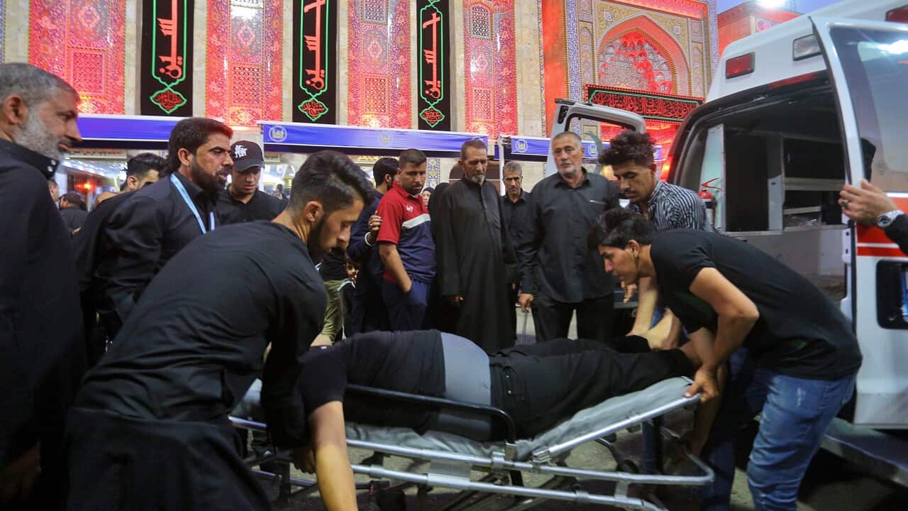 People evacuate an injured man after a walkway collapsed and set off a stampede as Shiite Muslims marked one of the most solemn holy days of the year