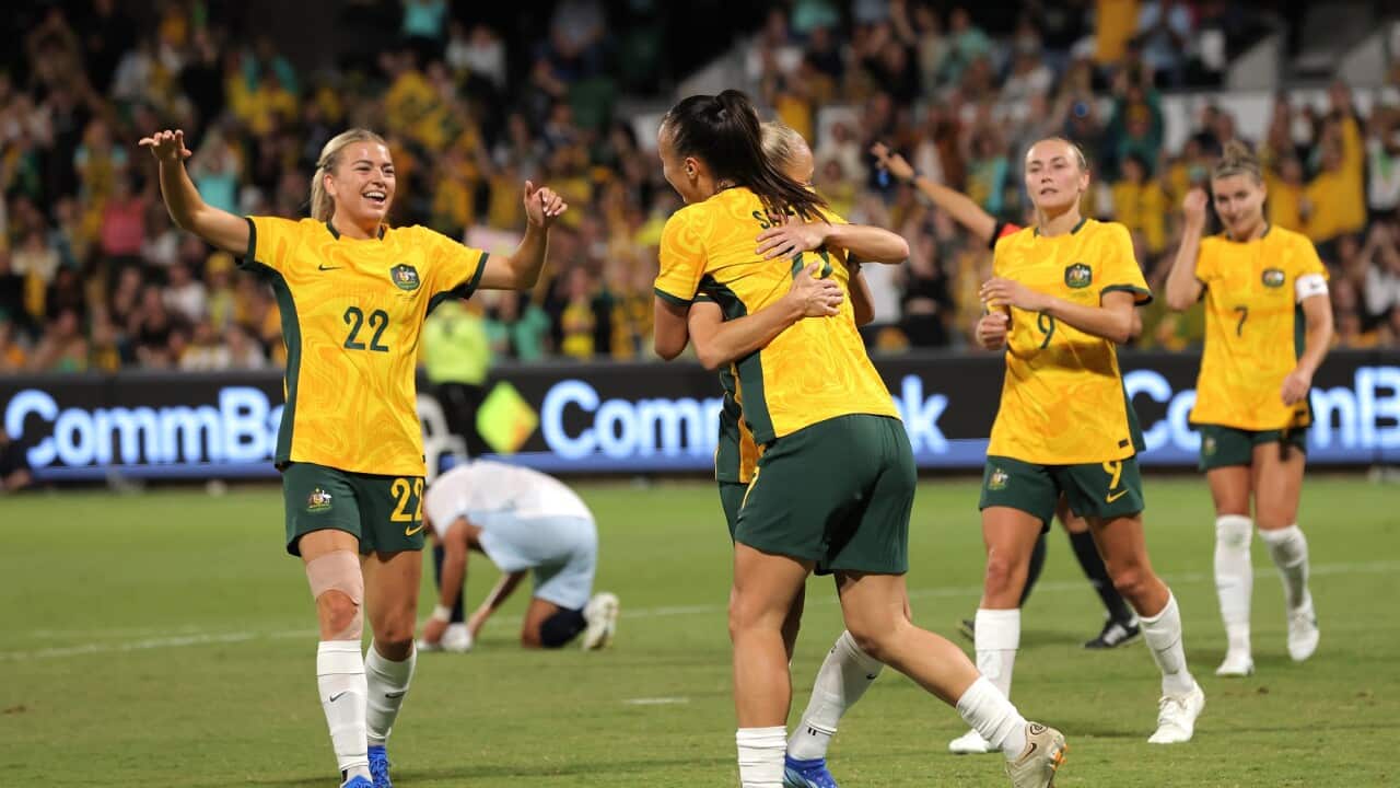 Matildas players hug each other.