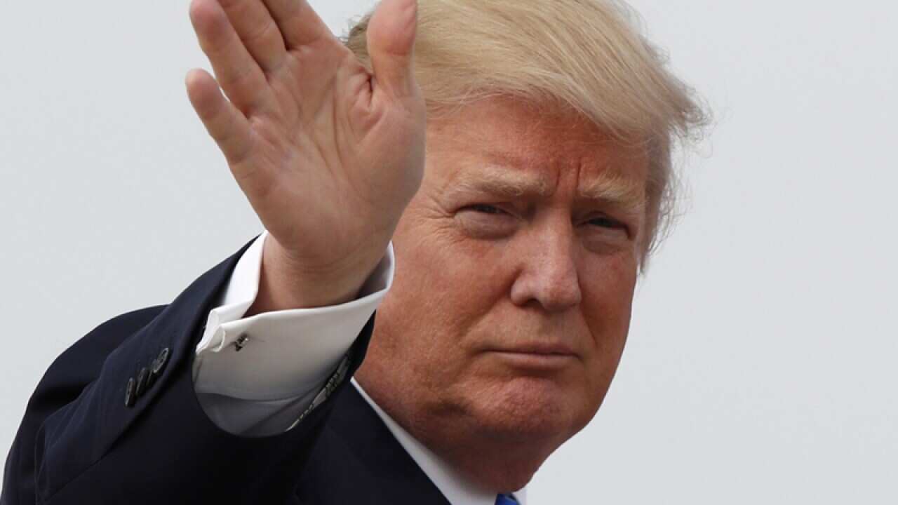 President Donald Trump waves as he boards Air Force One