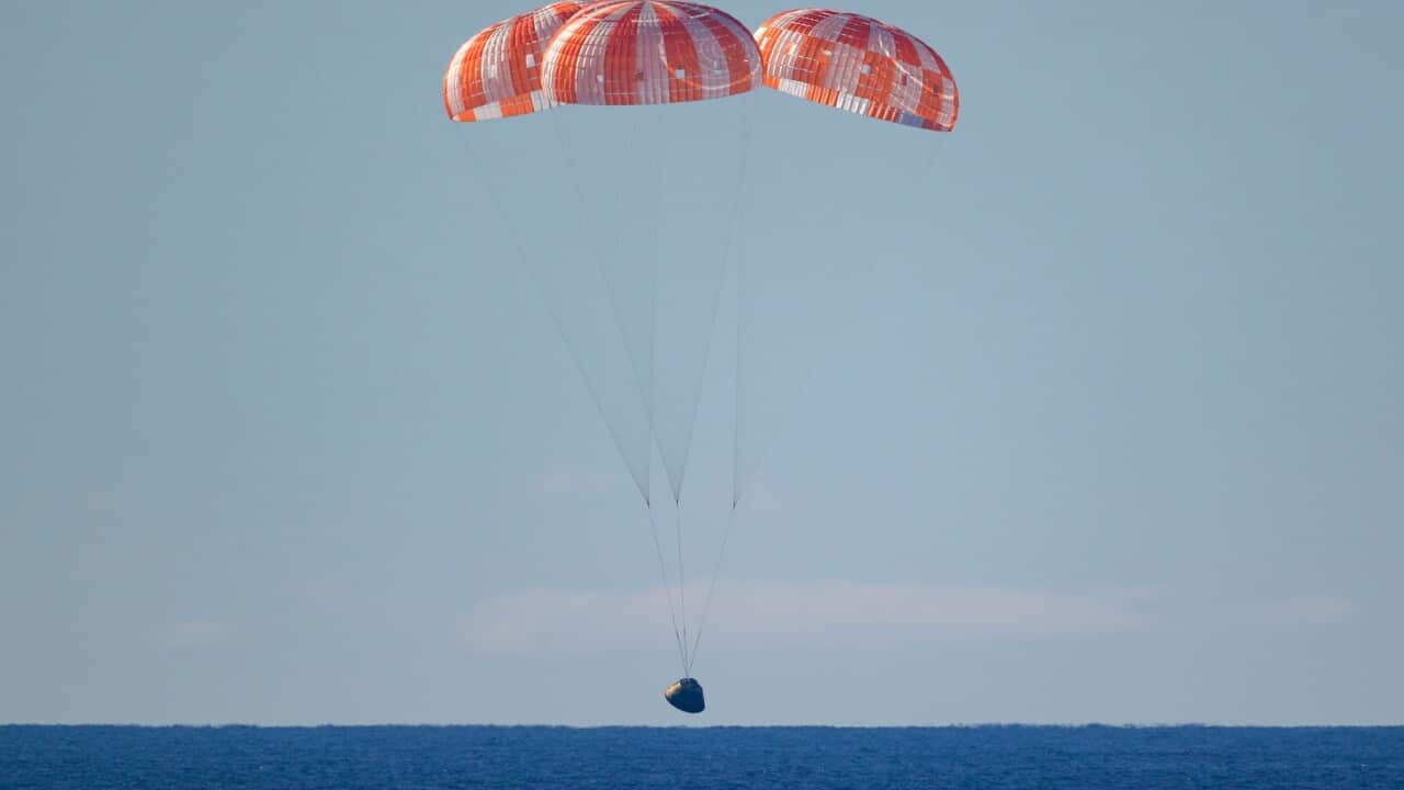 In this photo provided by NASA, the Orion spacecraft with Artemis II crewmembers aboard approaches the surface of the Pacific Ocean for splashdown off the coast of California.