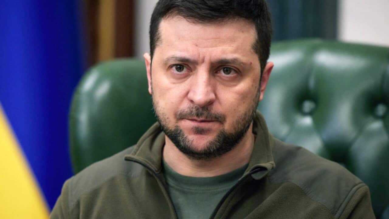 Ukrainian President Volodymyr Zelenskyy is seen sitting in a chair during an address to the nation.