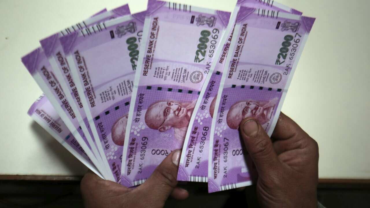 A bank executive counts new 2000 Indian rupee notes at a bank in Srinagar, the summer capital of Indian Kashmir, 10 November 2016.