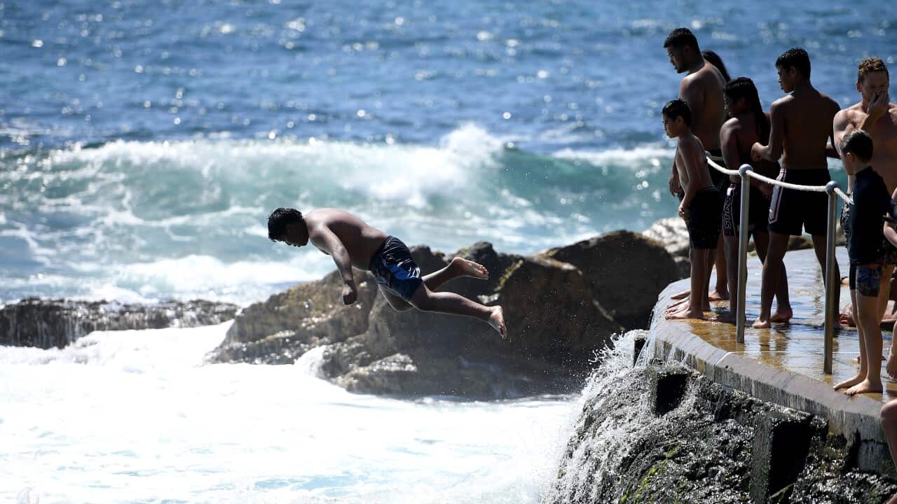 A person jumps off the rocks at Bronte beach, in Sydney.